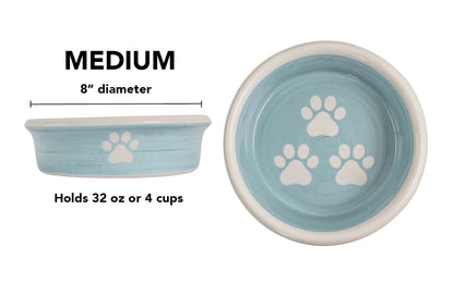 Medium sky blue handmade ceramic dog bowl with white paw prints, 8-inch diameter and 4-cup (32-ounce) capacity.
