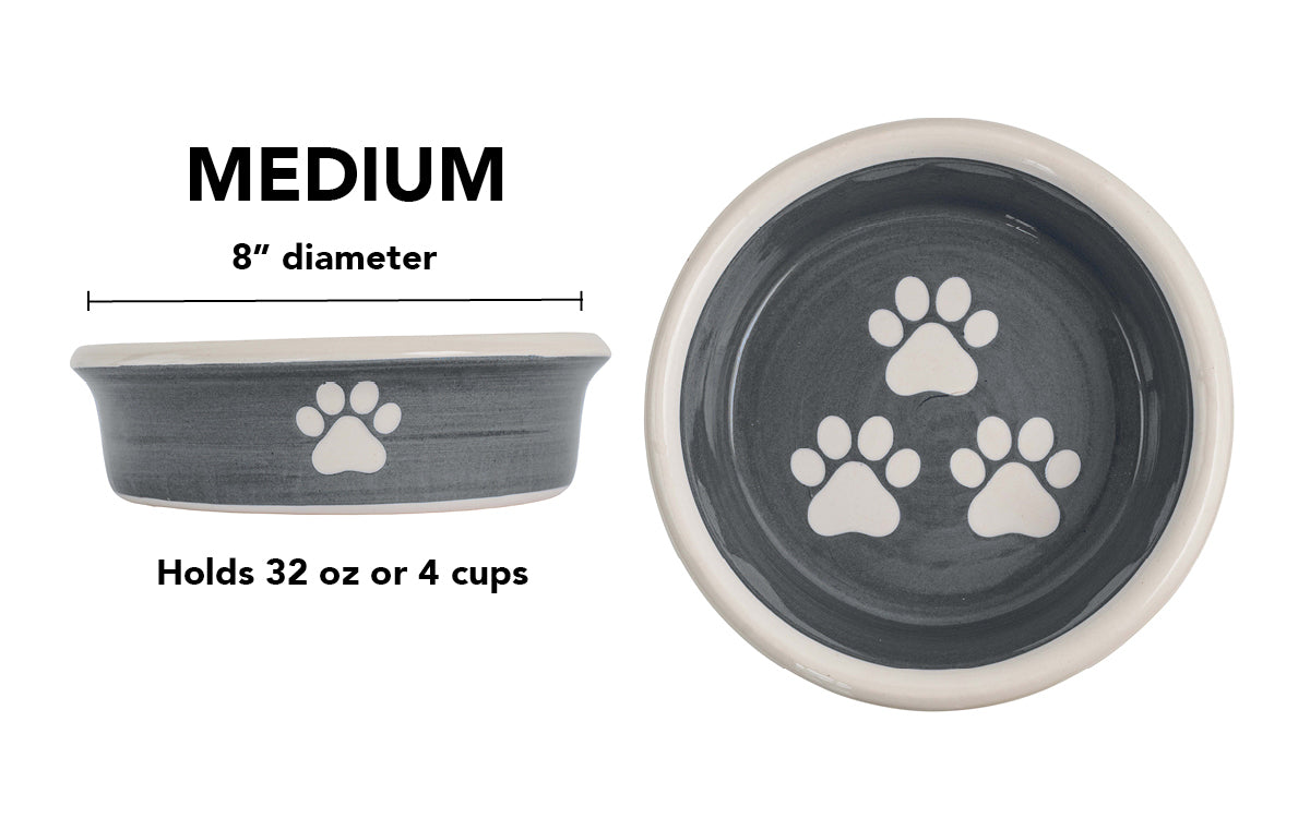Medium charcoal gray handmade ceramic dog bowl with white paw prints, 8-inch diameter and 4-cup (32-ounce) capacity.
