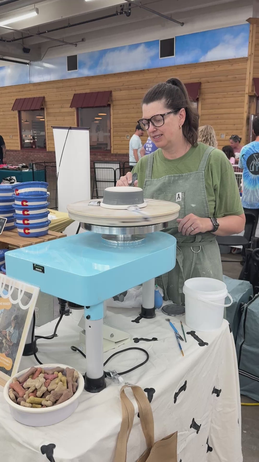Load video: Julie decorating handmade ceramic dog bowls for Petware Pottery at a Denver dog show